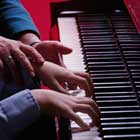 teacher giving child piano lesson